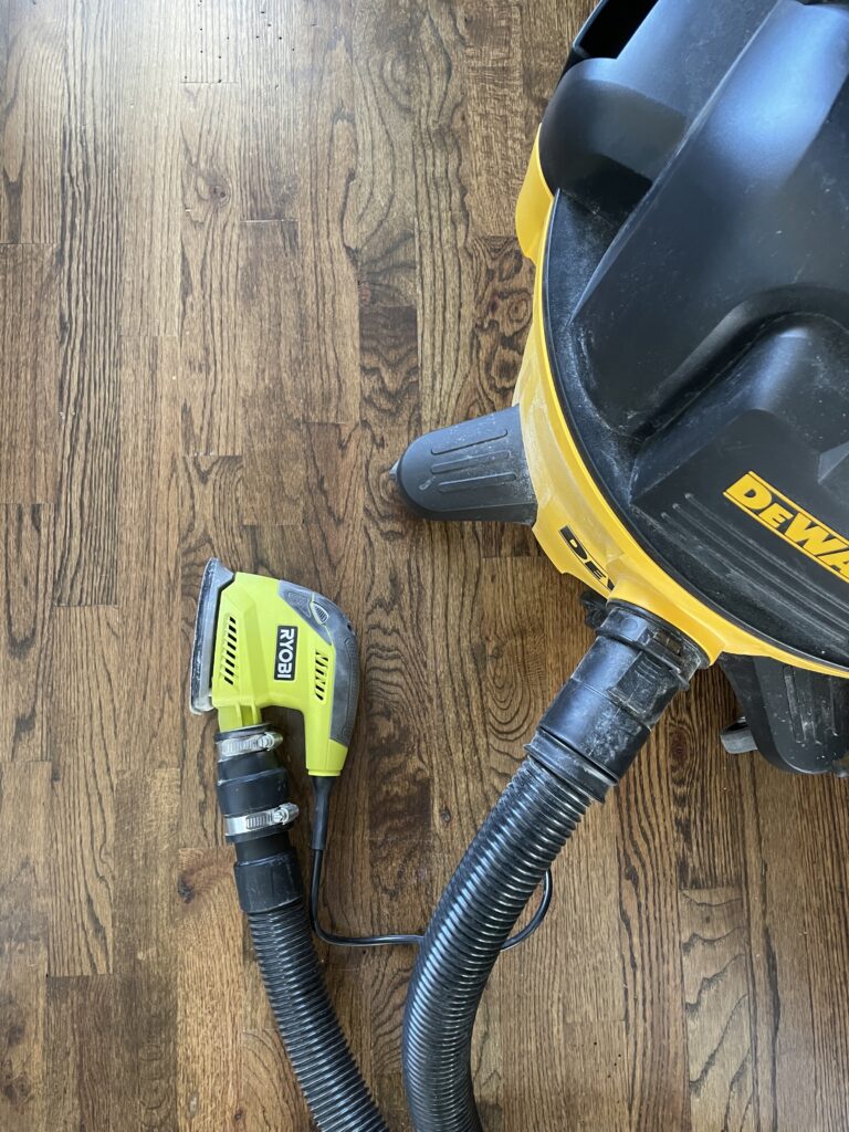 A shop vac connected to a mouse sander using a pvc adapter. This is a hack used to prevent dust from getting everywhere when you're sanding indoors.