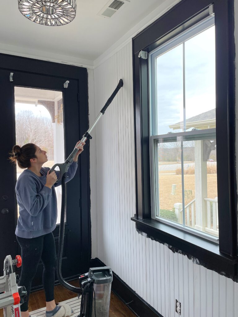 Elisha from Our Aesthetic Abode is vacuuming the dust off the walls in preparation for paint for her beadboard entryway makeover.