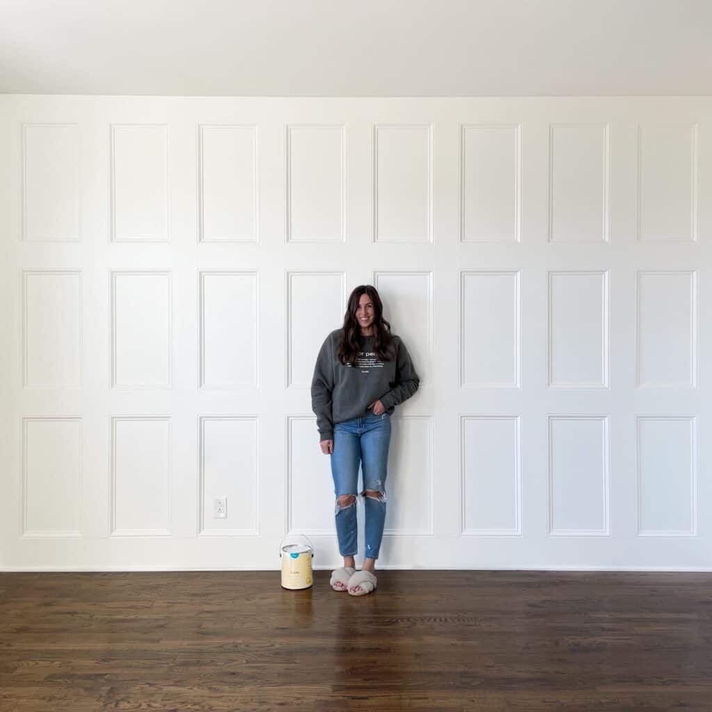 Elisha from Our Aesthetic Abode is standing in front of her completed diy recessed wainscoting accent wall.