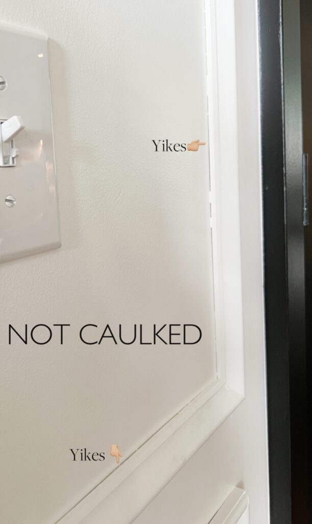 Elisha from Our Aesthetic Abode is showing a photo of her box molding that is *not* caulked. The photo has text that says "yikes" and points to a couple areas that have not been caulked