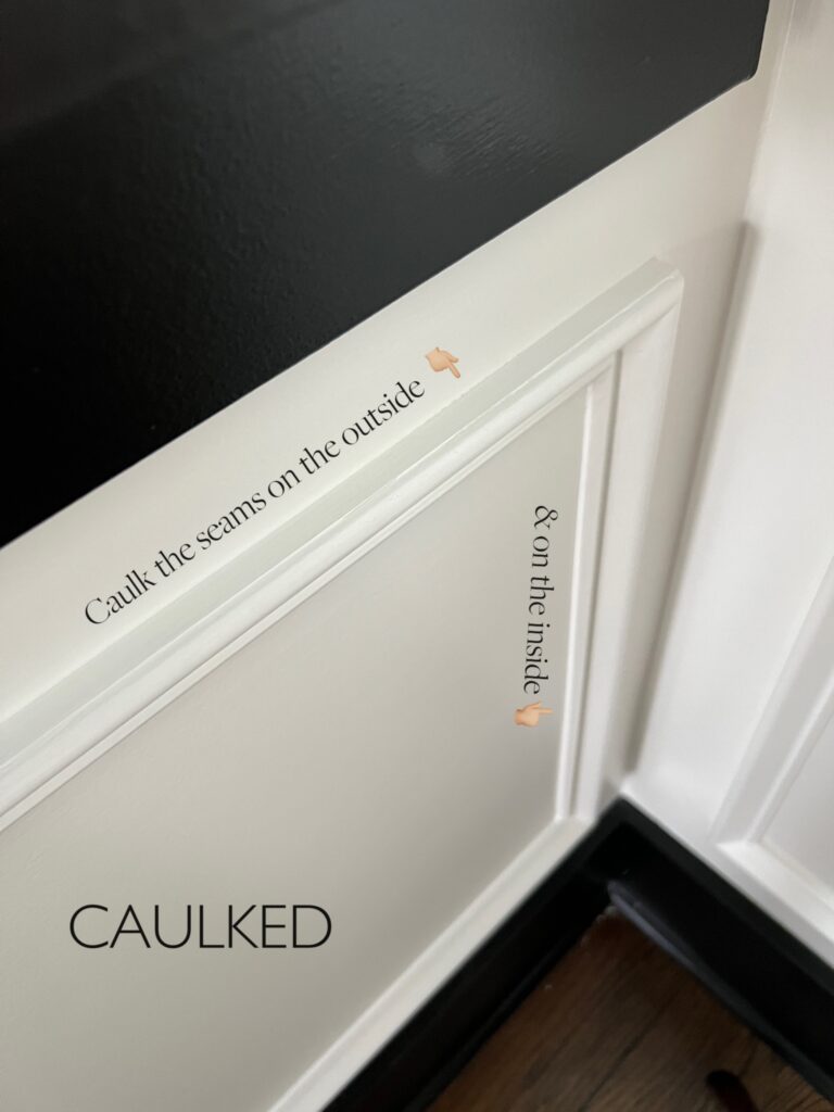 Elisha from Our Aesthetic Abode is showing a photo of her box molding that is caulked. The photo has text that says, "caulk the seams on the outside" and "& on the inside"