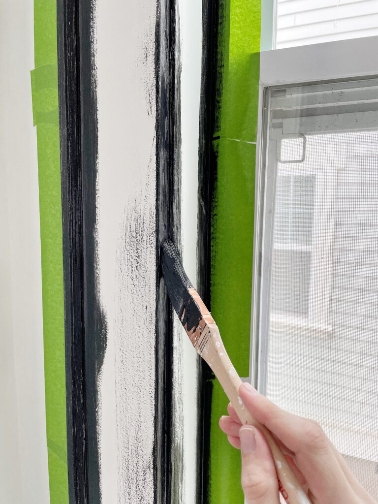 A small angled brush painting window trim black