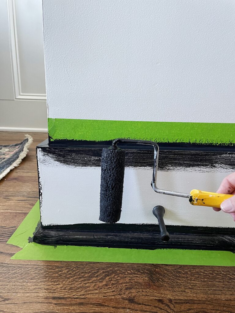 Painting a baseboard black using a 3/8" nap roller