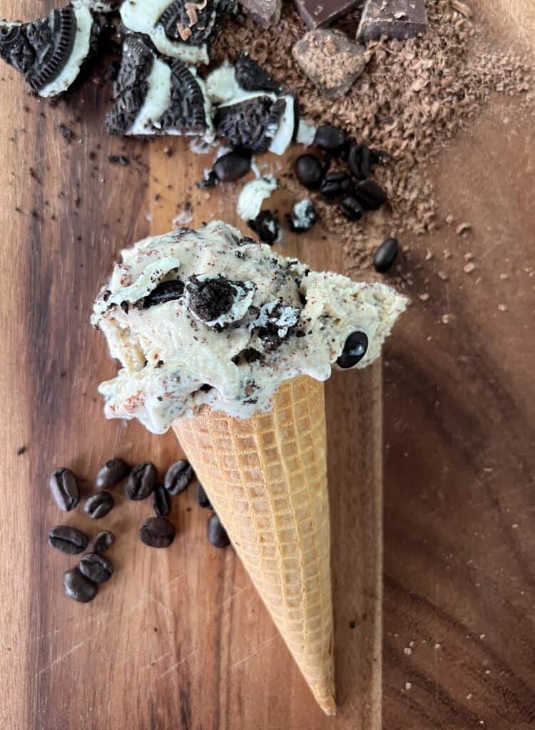 a small bowl of homemade coffee ice cream with chopped Oreos and coffee beans