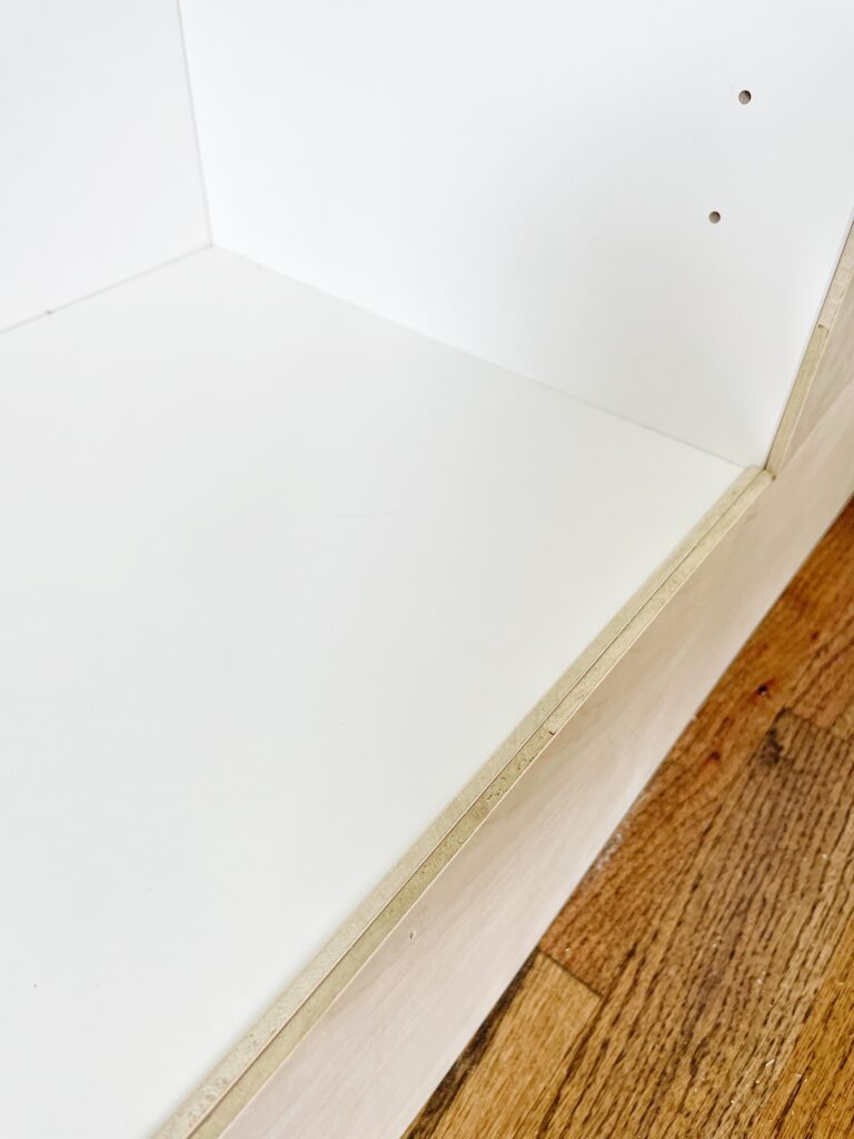 Bottom shelf of Ikea Billy bookcase with a gap that was filled with a 1/4" piece of plywood