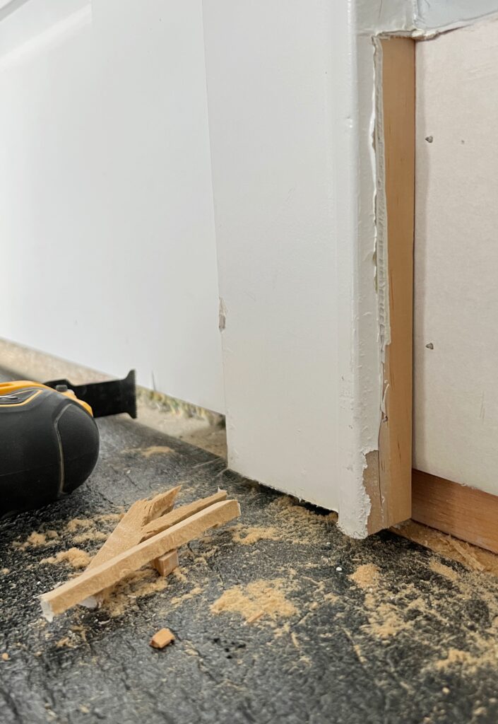 Using a multi-tool to cut into a door Fram for installing flooring