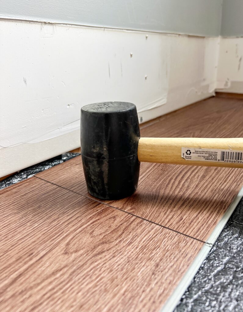Tapping in a floating floor plank while installing LVP