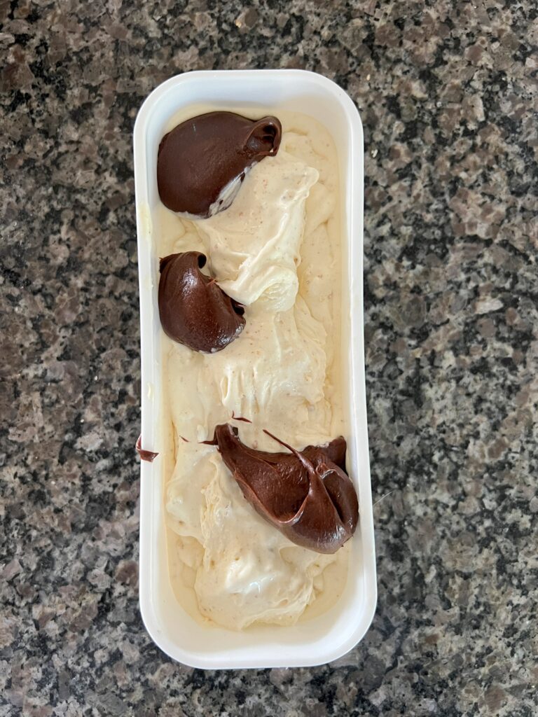 Dollops of chocolate frosting swirl into homemade ice cream