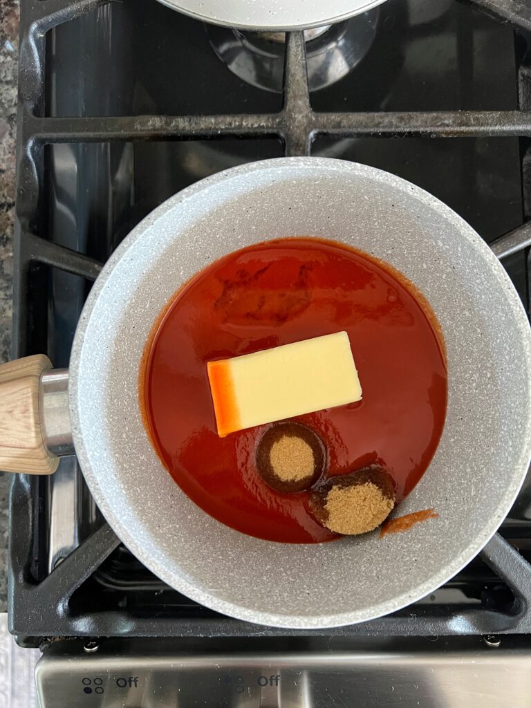 a saucepan with hot sauce, butter, brown sugar, and vinegar to make a homemade buffalo sauce