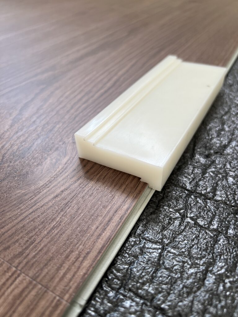 a tapping block on luxury vinyl plank flooring