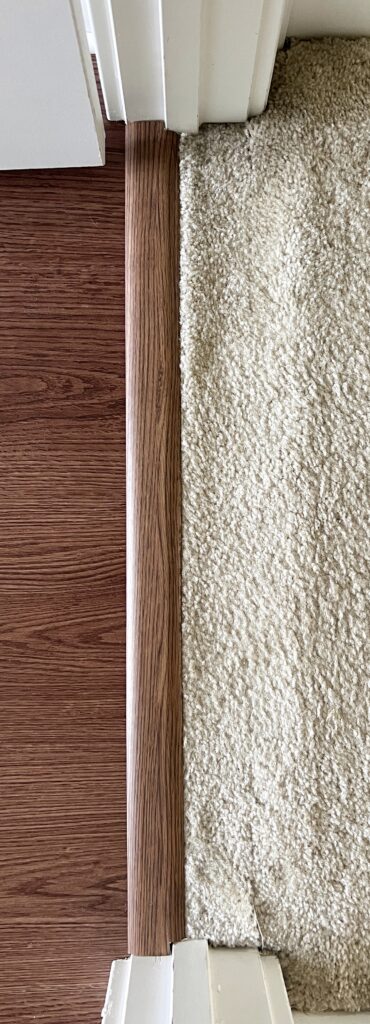 A transition piece from LVP flooring to carpet