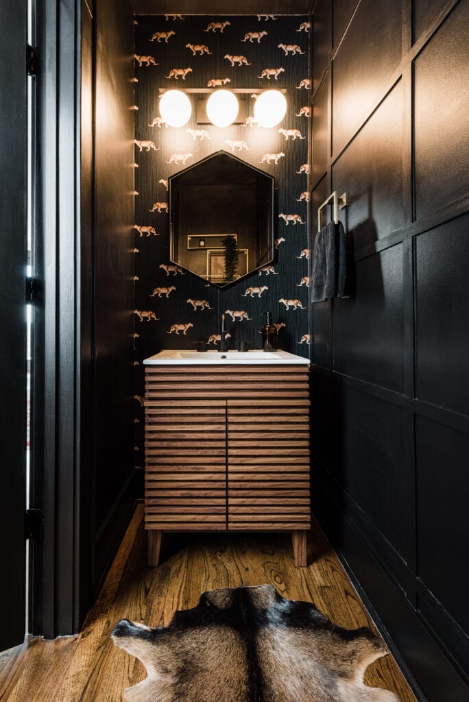 a black powder room with leopard wallpaper