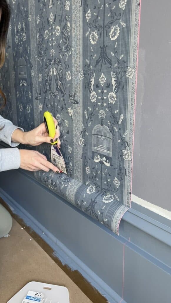 using a zinsser four in one tool to trim excess wallpaper