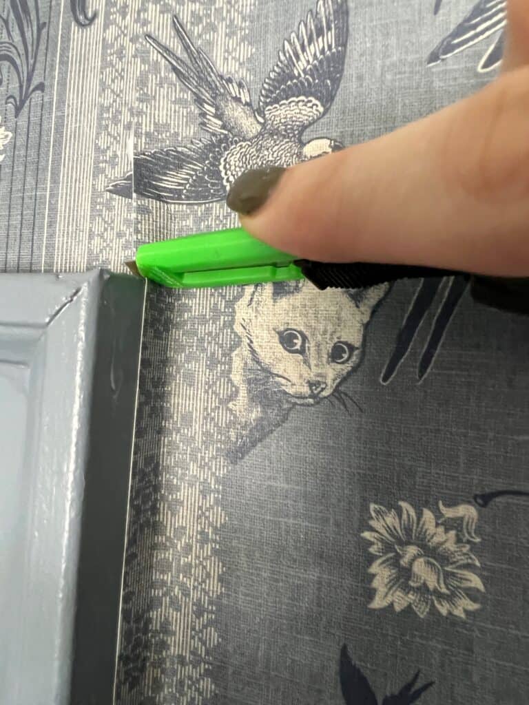 cutting into the wallpaper around the door frame