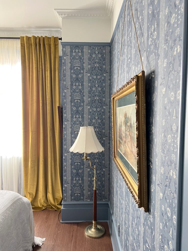 vintage brass floor lamp in a wallpapered bedroom