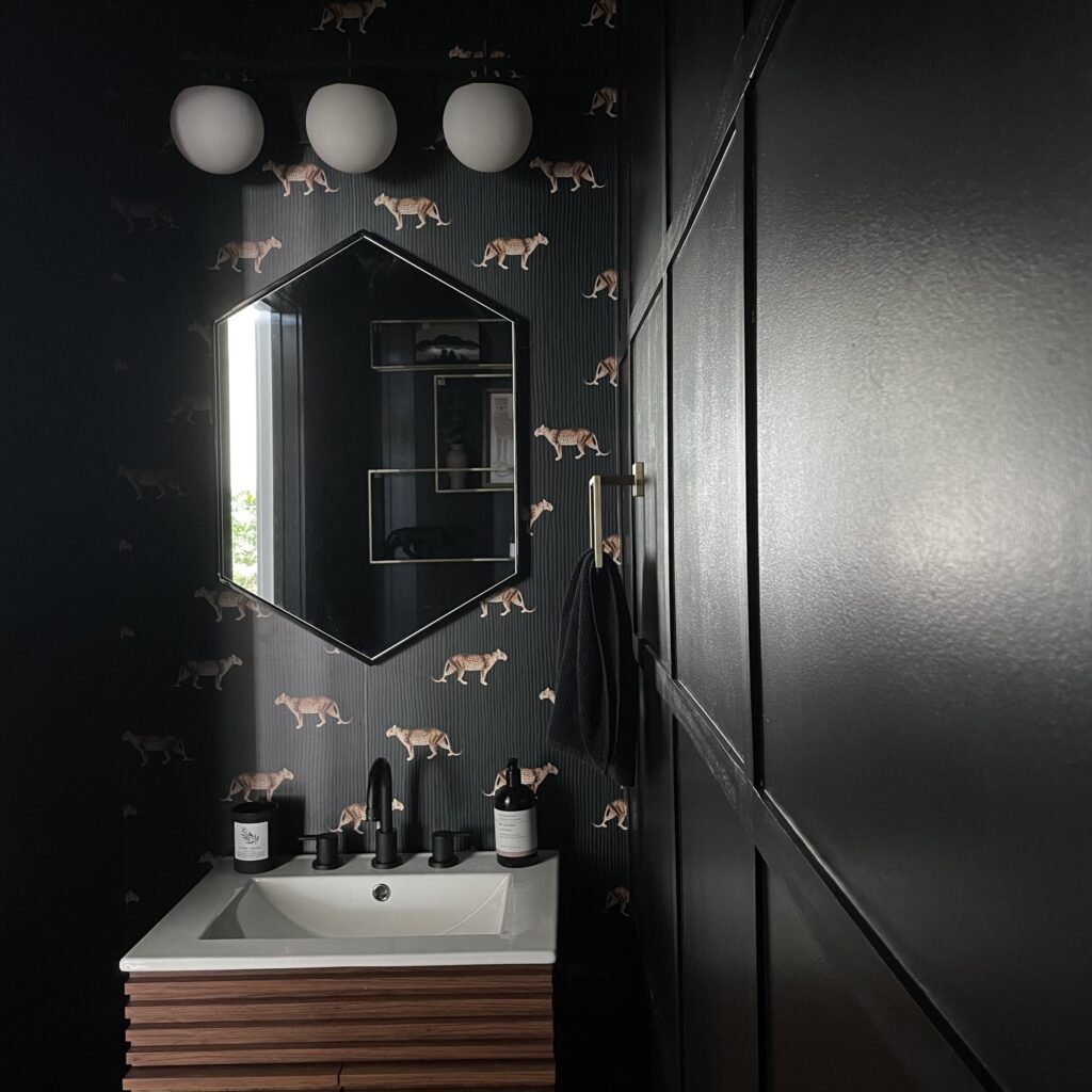 a bold and modern powder room makeover with black paint (Behr Limousine Leather)