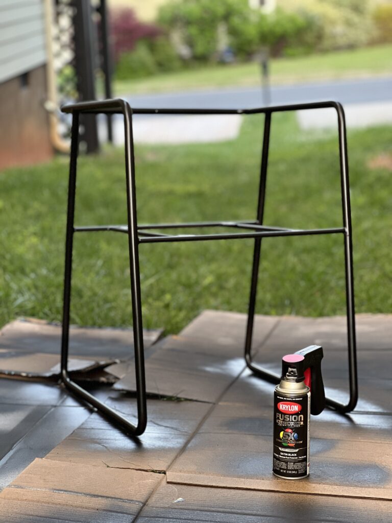 the metal base of a chair after one coat of Krylon fusion all-in-one satin black spray paint