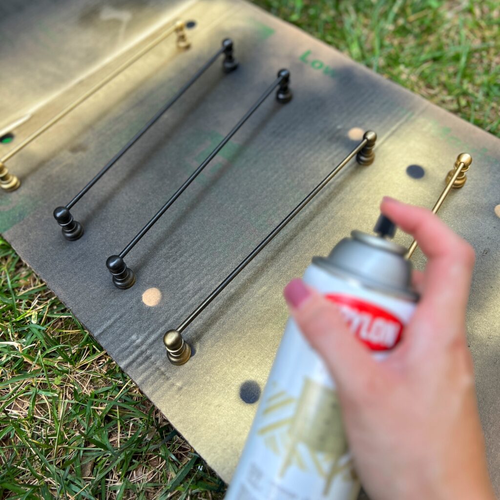 DIY brass gallery rails being spray painted with Krylon gold leaf