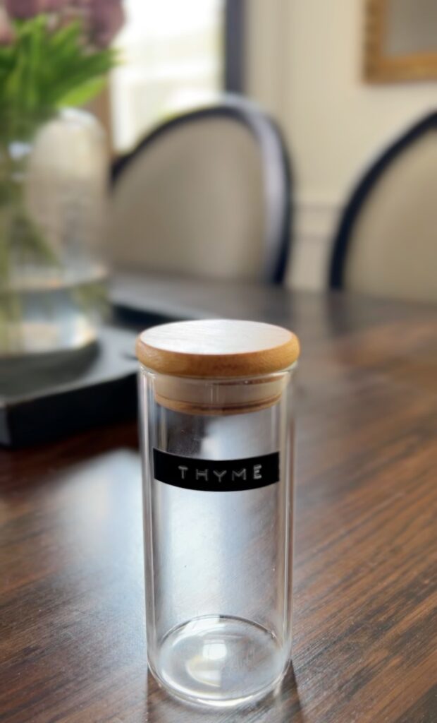 Glass spice jar with a wood top and black label