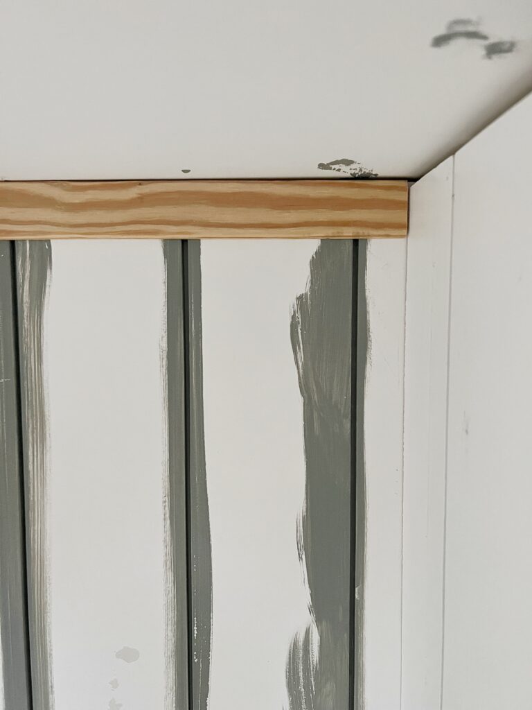 A wood trim piece to cover where shiplap meets the ceiling