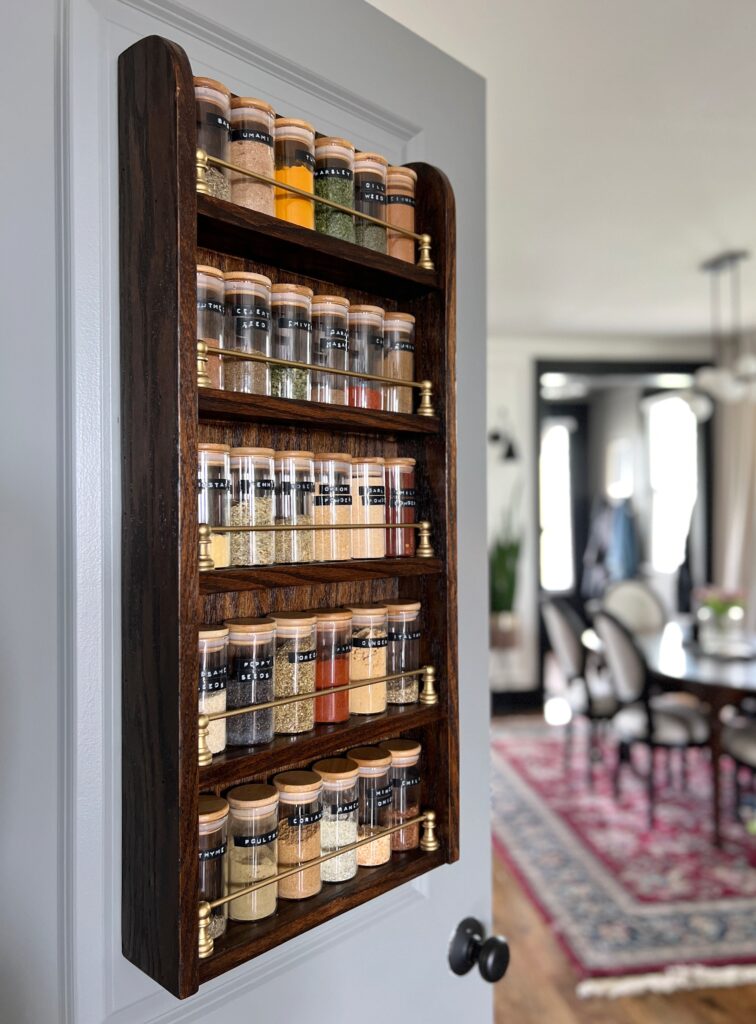 a DIY curved wood spice rack on a pantry door with brass rods