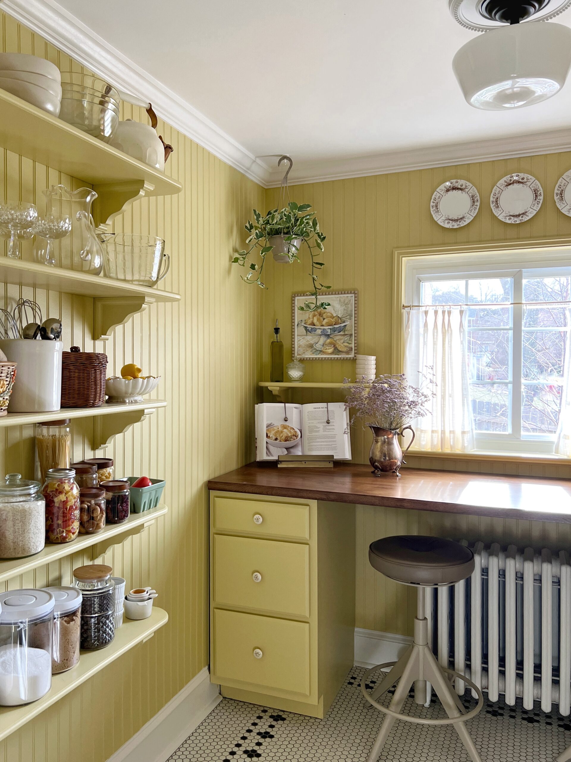 Charming yellow walk-in pantry with floating shelves and vintage style decor